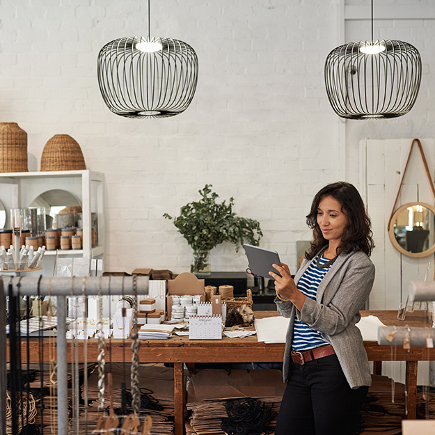 Business owner looking at Liberty Air security software on tablet.